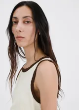 Musculosa de tejido de algodón color blanco crudo, de diseño recto, con cuello redondo y detalles festoneados en contraste de color marrón en cuello y sisas.