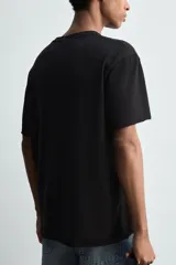 Camiseta de corte relajado confeccionada en algodón ligero, con cuello redondo y mangas cortas con bordes de acabado irregular.