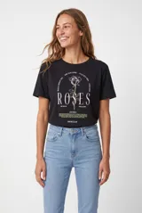 Remera de manga corta color blanco con estampa frontal ilustrada que incluye una serpiente, rosas y la leyenda "All I Ever Wanted".