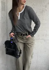 Remera rayada en blanco y negro de manga larga, con cuello redondo y cartera de botones frontal en contraste blanco.