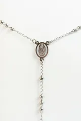 Collar tipo rosario plateado en acero quirúrgico, con cuentas y cruz colgante.