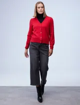 Cardigan rojo tejido en hilado fino, con escote en V y abertura central con botones metálicos.
