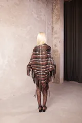 Ruana artesanal confeccionada en cuero de napa ovina entrelazado con diseño geométrico, terminada con flecos largos en tonos marrón, negro y blanco.
