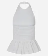 Top blanco de tejido piquet texturizado, con cuello halter y peplum con volado en la cintura.