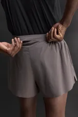 Short de running confeccionado en tejido técnico ligero y elástico con estructura. Cuenta con forro interior, cintura elástica ajustable con cordón, bolsillo trasero con cierre oculto, bolsillos laterales multifunción y aberturas laterales en las perneras.