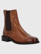 Bota tipo chelsea de cuero color marrón, con paneles elásticos laterales en color marrón oscuro, suela de goma negra y taco cuadrado bajo.