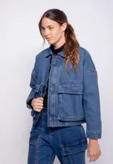 Campera de jean azul con fit holgado, bolsillos frontales grandes, elástico en la cintura y forro interior de corderito.