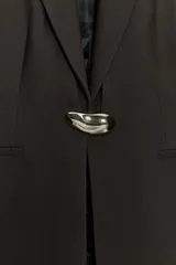 Blazer entallada de cuello solapa y manga larga con hombreras. Presenta bolsillos delanteros de vivo y cierre frontal con un botón metálico decorativo.
