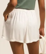 Short de viscosa texturizada color blanco, modelo holgado con cintura de sastrería en la parte delantera, elástico en la parte trasera, trabillas, cierre por botón y cremallera, y bolsillos laterales.