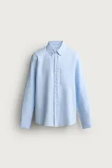 Camisa regular fit de manga larga con diseño a rayas verticales celestes y blancas. Cuenta con cuello abotonado, bolsillo de parche en el pecho y cierre frontal con botones.