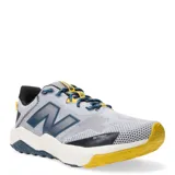 Championes de trail running New Balance Nitrel, color gris con detalles en azul y amarillo. Presentan capellada de malla transpirable con refuerzos sintéticos, entresuela de espuma EVA y suela de goma AT Tread para tracción en terrenos variados.