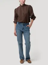 Pantalón de jean tiro alto y pierna recta, con diseño clásico de cinco bolsillos y cierre frontal con botón metálico.