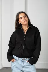 Campera corta de gamuza color marrón, con cierre frontal, cuello camisero y bolsillos frontales con solapa.