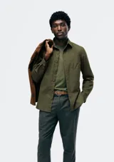 Camisa de vestir azul marino, de corte clásico, con cuello abotonado, manga larga y bolsillo en el pecho.