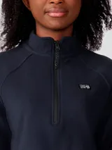 Polar Mountain Hardwear modelo Microchill 1/4 Zip de color negro, con cuello alto, cierre frontal de un cuarto de longitud y mangas raglán. Presenta un pequeño parche con el logo de la marca en el pecho.