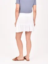 Falda corta de color negro, con cintura elástica tipo nido de abeja y ruedo con volado.