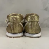 Championes dorados de cuero, marca Champion, con cordones y detalles en blanco.