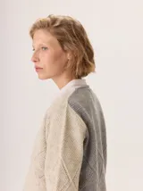 Buzo de lana color marrón topo, con cuello en V y diseño de punto calado en rombos en el frente y mangas.