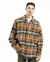 Sobrecamisa de franela a cuadros en tonos ocre, negro, rojo y blanco, con cuello clásico, cierre frontal con botones, dos bolsillos con solapa abotonada en el pecho, mangas largas con puños abotonados y corte recto.