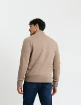 Cardigan de punto gris con cuello alto, cierre frontal de metal con doble cursor y bolsillos laterales. Presenta puños y cuello en tejido canalé.