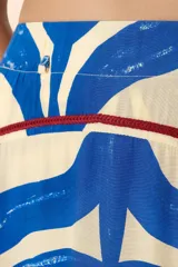 Falda larga de corte amplio con estampado de hojas en azul y blanco. Presenta detalles de bordado en tono vino en las costuras y aberturas laterales que aportan movimiento.