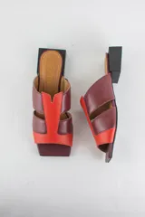 Sandalias descalzas de cuero combinadas en tonos bordó y rojo, con taco cuadrado bajo y puntera cuadrada.