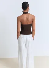 Top marrón con escote halter y tirantes anchos. Diseño ajustado sin cierre.