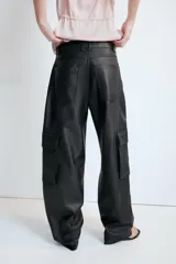 Pantalón cargo de tiro alto confeccionado en material efecto piel. Presenta bolsillos laterales con solapa, bolsillos delanteros y traseros, con cierre frontal de cremallera y gancho metálico.