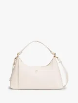 Cartera Tommy Hilfiger de poliuretano color beige, con cierre superior de cremallera, asa corta y correa extraíble. Cuenta con el monograma metálico de la marca en el frente.