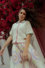 Saco tejido a crochet color crudo con detalles de terminación en rosa, verde y celeste.