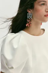 Pendientes tipo cascada con estructura superior geométrica decorada con cristales y flecos inferiores compuestos por piedras naturales en tonos coral y ámbar.