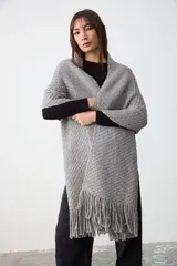 Chal de punto grueso con textura, color gris, confeccionado en una mezcla de lana merino extrafina, lino y viscosa. Diseño ligero y suave con caída envolvente.