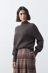 Polera de tejido de punto en color marrón oscuro, con cuello alto y diseño de silueta relajada.