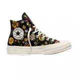 Championes Converse modelo Chuck 70 de caña alta, con diseño estampado de flores en tonos amarillos, rosas y verdes sobre base negra. Presenta el parche clásico de la marca en el lateral, puntera de goma y suela de plataforma en color crema.