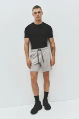 Short deportivo gris claro de tejido funcional con tecnología DryMove™, corte estándar, cintura elástica con cordón de ajuste negro, bolsillos laterales y aberturas en el bajo.