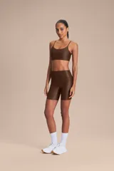 Biker deportiva de tiro alto confeccionada en tejido Allure con tecnología Lycra Adaptiv, de compresión media a alta, con acabado satinado y bolsillos laterales funcionales.