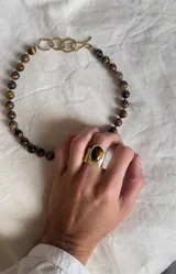 Anillo de bronce con piedra ojo de tigre ovalada.