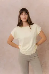 Remera básica color celeste, de corte relajado, cuello redondo y mangas cortas con hombro caído y dobladillo.