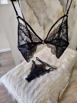 Conjunto de lencería compuesto por un bralette de encaje con detalle de aro central y una tanga colaless de doble tira regulable.