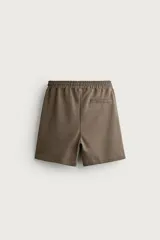 Bermuda estilo jogger de ajuste relajado, confeccionada en tejido interlock de algodón. Cuenta con cintura elástica ajustable con cordón, bolsillos frontales de vivo y diseño liso.
