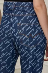 Pantalón de jean azul con estampado de letras en color blanco.