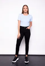 Pantalón chupín de tiro medio con textura similar al denim, en color negro.