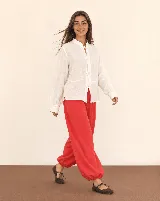 Pantalón rojo de corte holgado, estilo bombacho, con puños fruncidos en los tobillos.