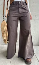 Jean de corte wide leg en color chocolate, confeccionado en denim con costuras verticales decorativas y ruedo deshilachado.