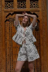 Short de tiro medio con pierna holgada, color blanco con estampado de motivos florales en tonos tierra. Presenta bolsillos delanteros y un cordón de ajuste en la cintura.