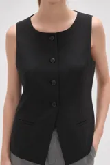 Chaleco sin mangas de corte sastrero, color marrón con diseño de rayas verticales finas. Presenta cuello redondo, cierre frontal con botones y dos bolsillos laterales simulados.