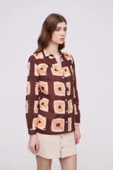 Camisa marrón con estampado de cuadrados color naranja y blanco, de corte holgado y manga larga.