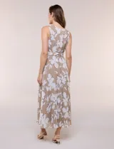Vestido maxi sin mangas de gasa plisada, color beige con estampado floral blanco. Presenta escote redondo fruncido, falda evasé y lazo para anudar en la cintura.