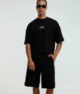 Bermuda baggy de algodón color negro, con cintura elástica con cordón de ajuste, bolsillos y detalles de recortes.