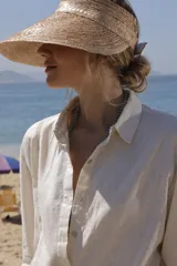 Camisa de lino blanca, de silueta oversize y calce relajado, con mangas largas y detalles de puntillas en la delantera.
